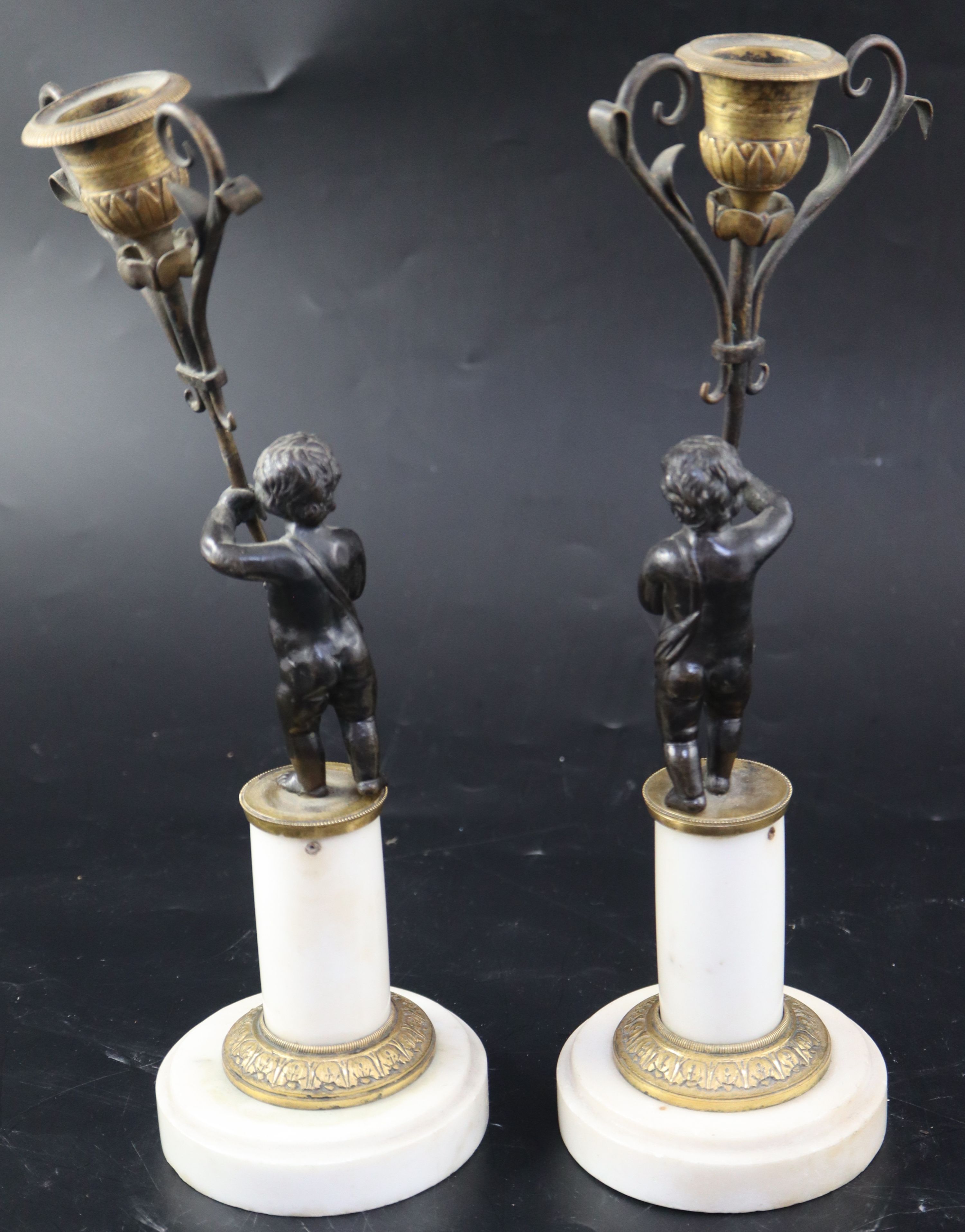 A pair of 19th century French bronze and ormolu candelabra, modelled with putti holding scrolling branches
